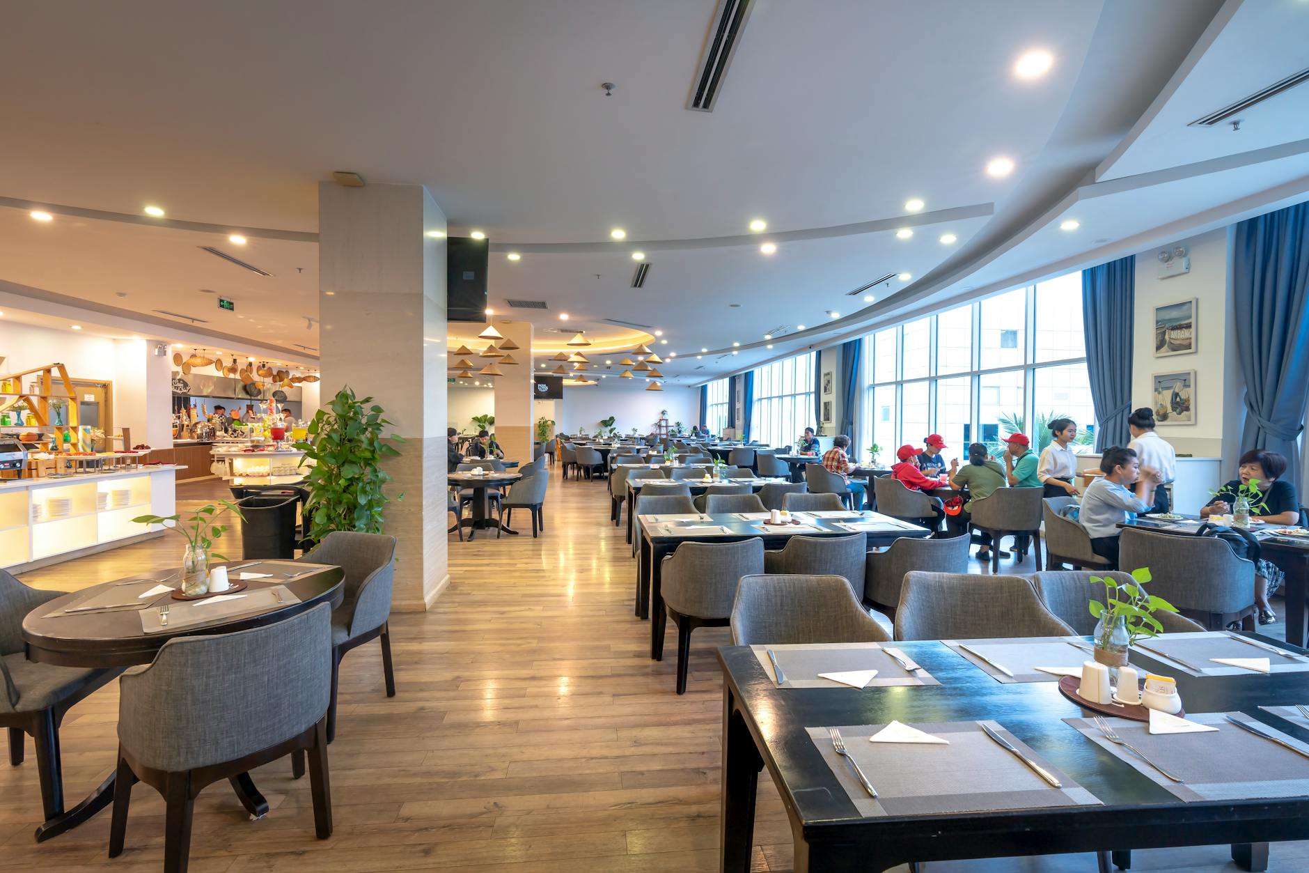 Goście jedzący w przestronnej restauracji z nowoczesnym wystrojem
