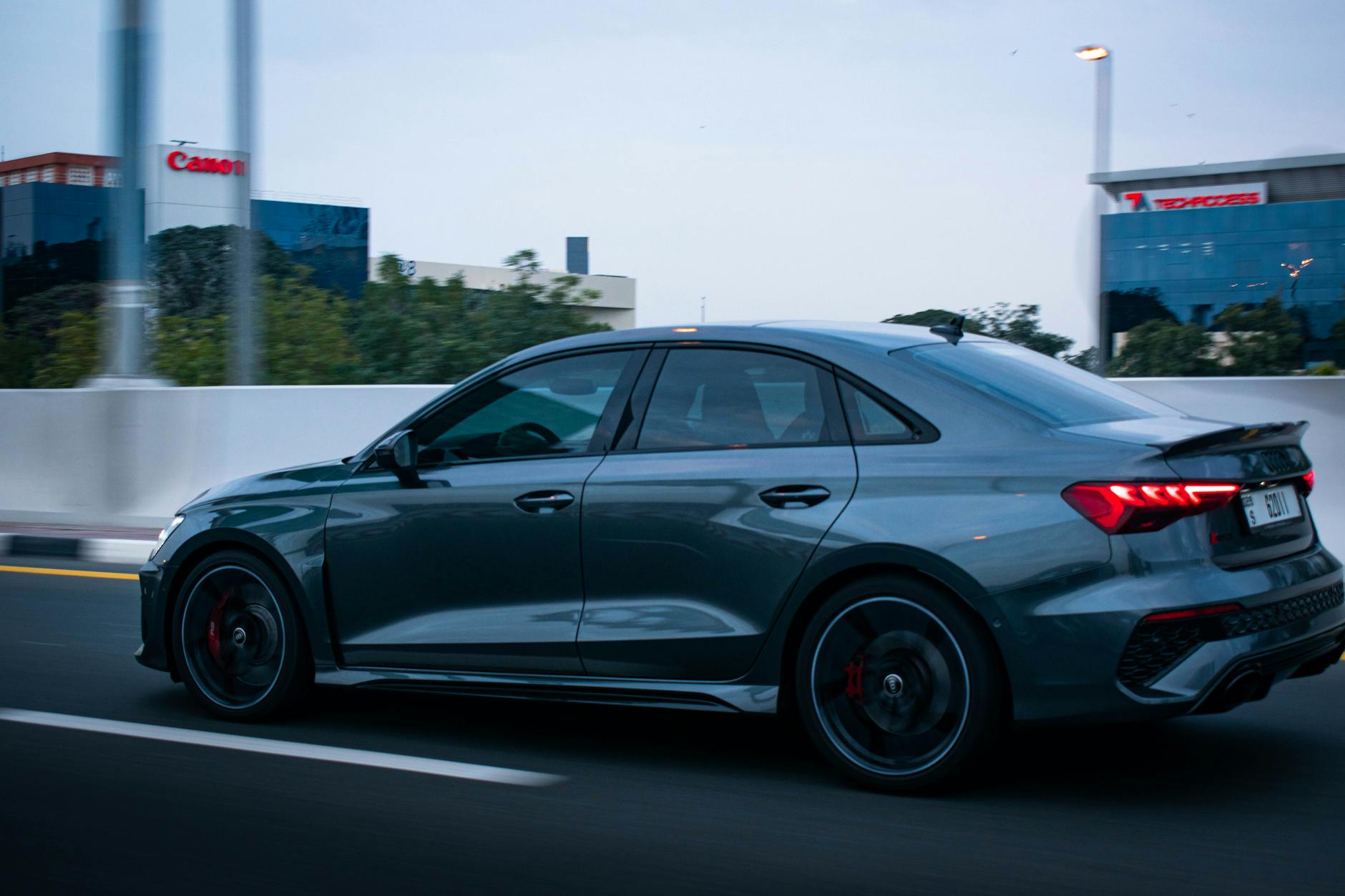 Jadące po mieście sportowe Audi na tle nowoczesnej zabudowy